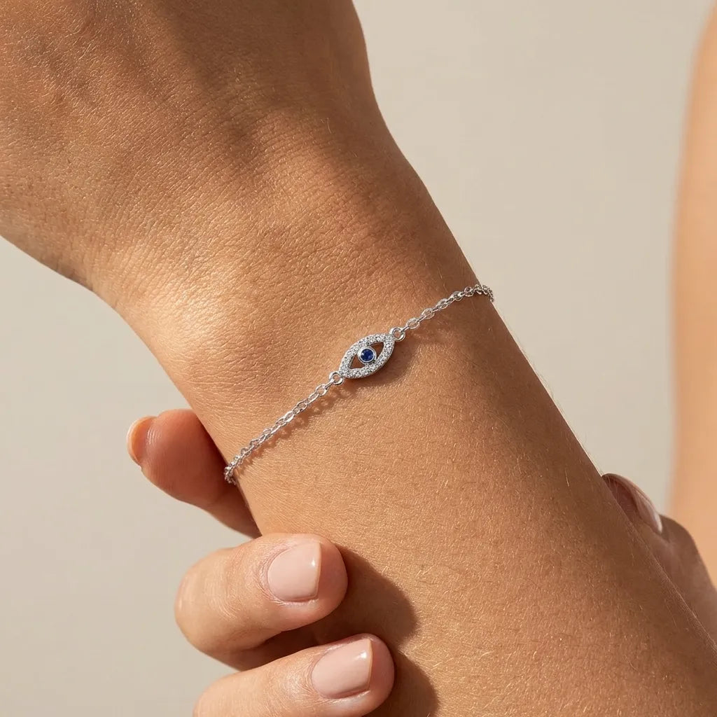 Woman wearing the Chloé silver evil eye bracelet, a crystal-rimmed eye with a blue center