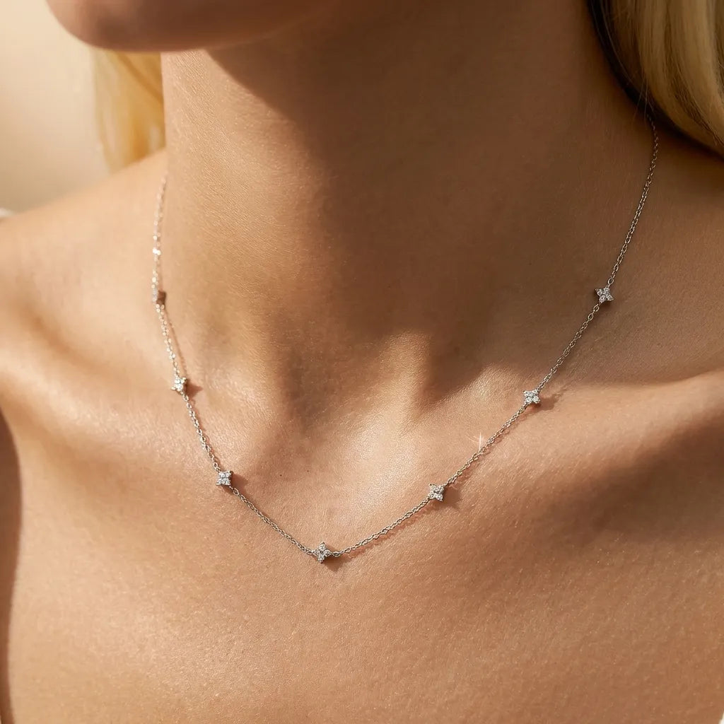Woman wearing the Camille silver chain necklace with small four-petal crystal stations