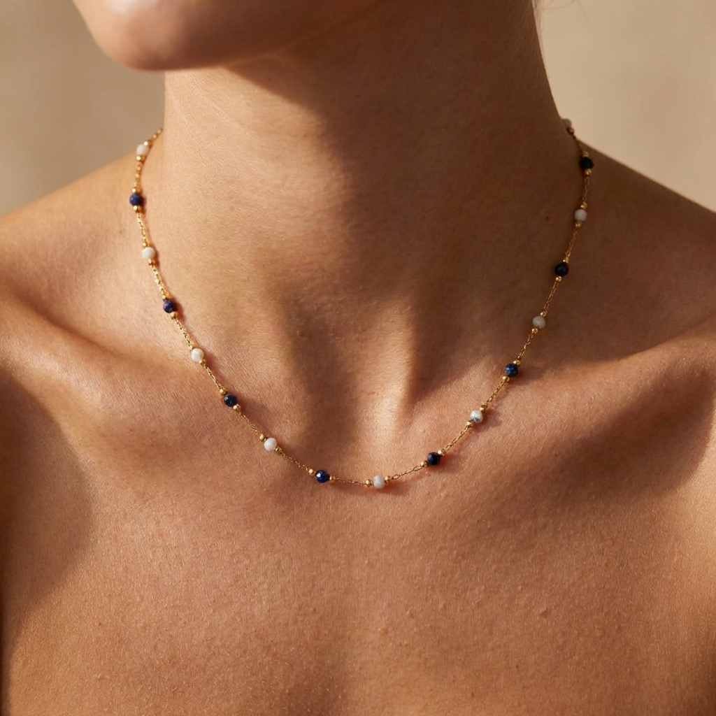 Woman wearing the Alla Midnight gold necklace with navy-blue and white beads along the chain