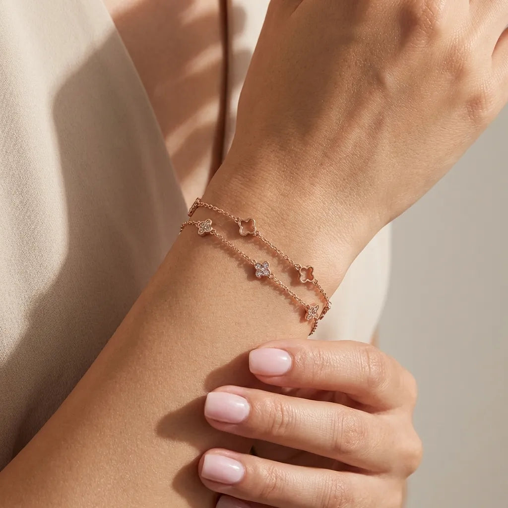 Ariana Clover bracelet in rose gold on the wrist, one strand of open clovers and one of crystal clovers