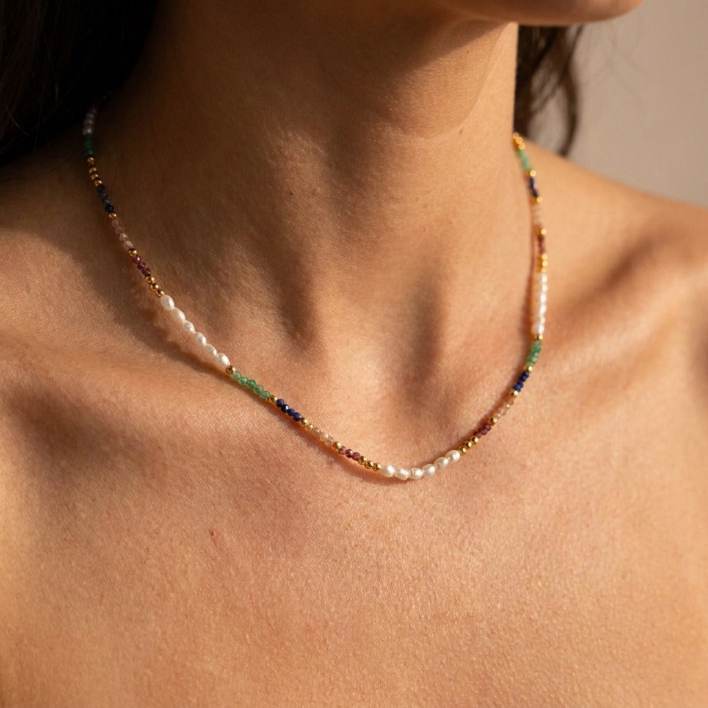 Woman wearing the Sienna beaded necklace with small pearls and green, blue and red beads
