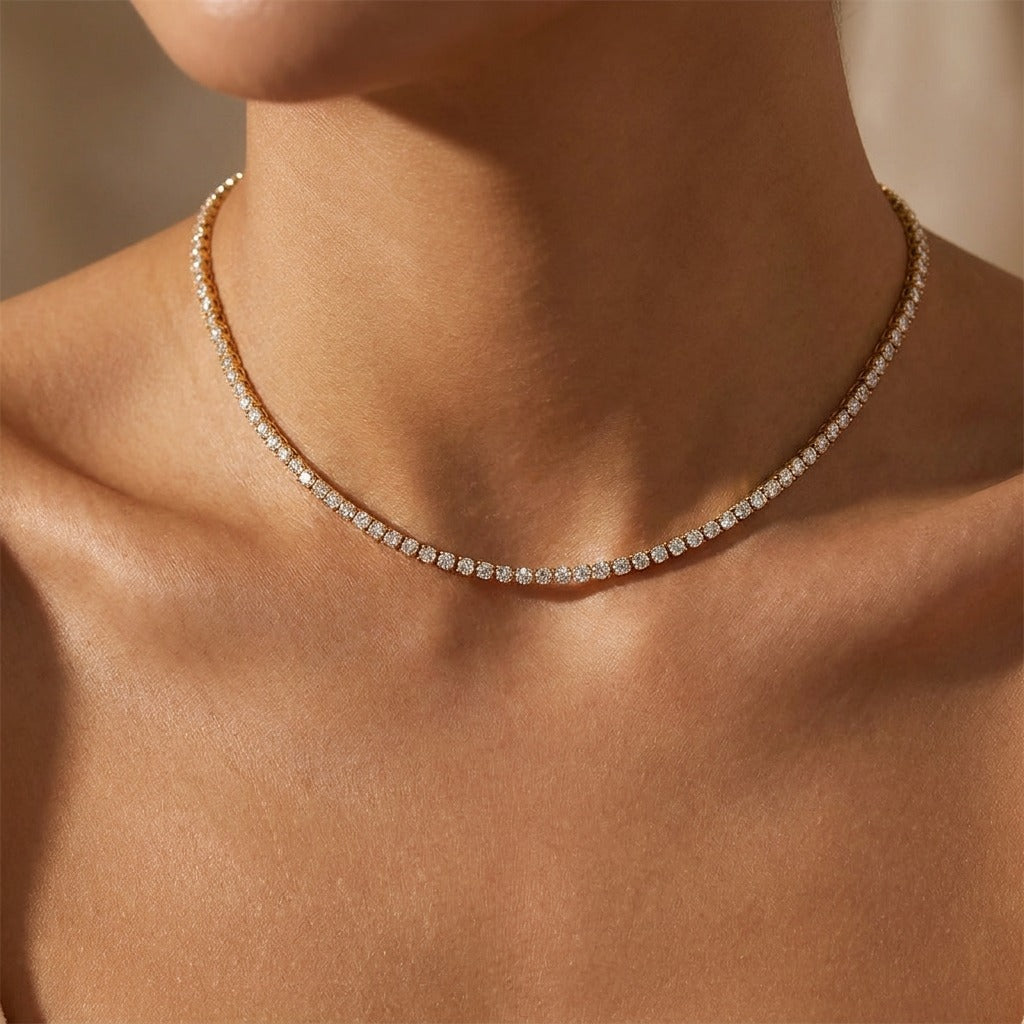 Woman wearing the Isolde gold tennis necklace, a row of clear cubic zirconia stones close at the neck