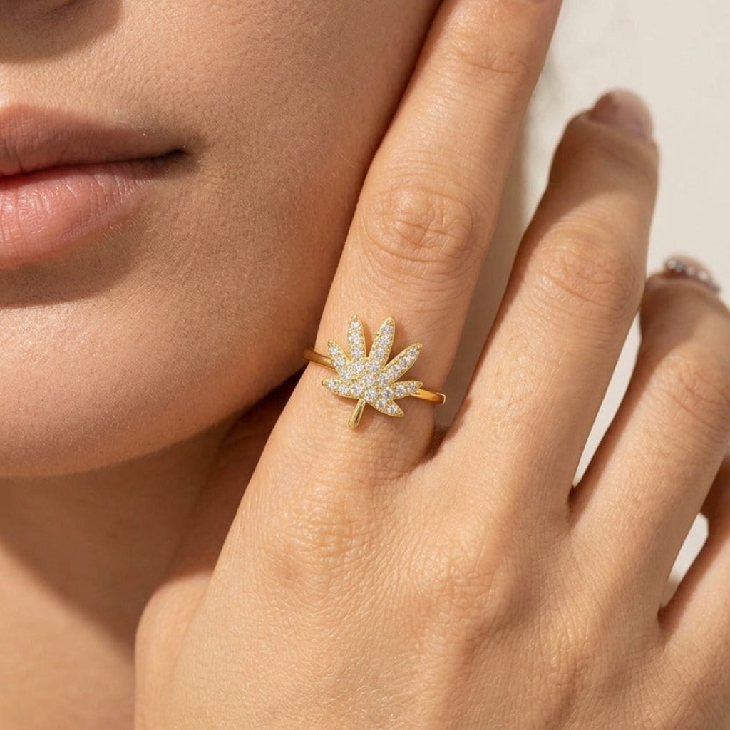 Close view of the Lydia crystal leaf ring on a finger, a gold leaf paved in crystals