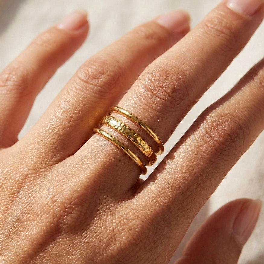 Woman wearing the Shirley gold ring with polished outer bands and a hammered band between them