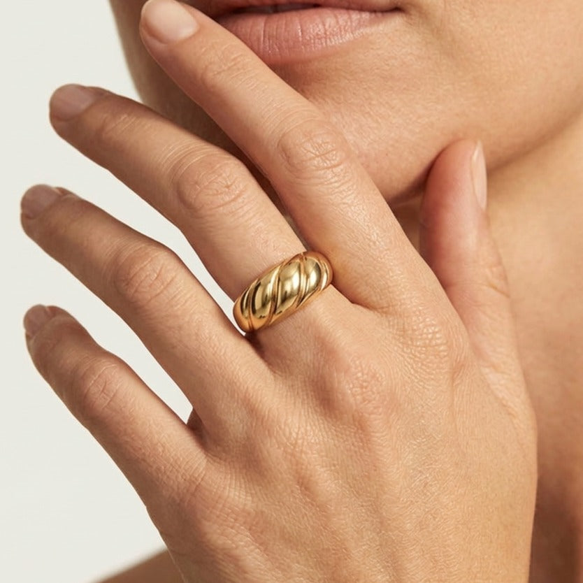 Woman touching her lips wearing the Lorelei gold croissant ring with twisted dome ridges