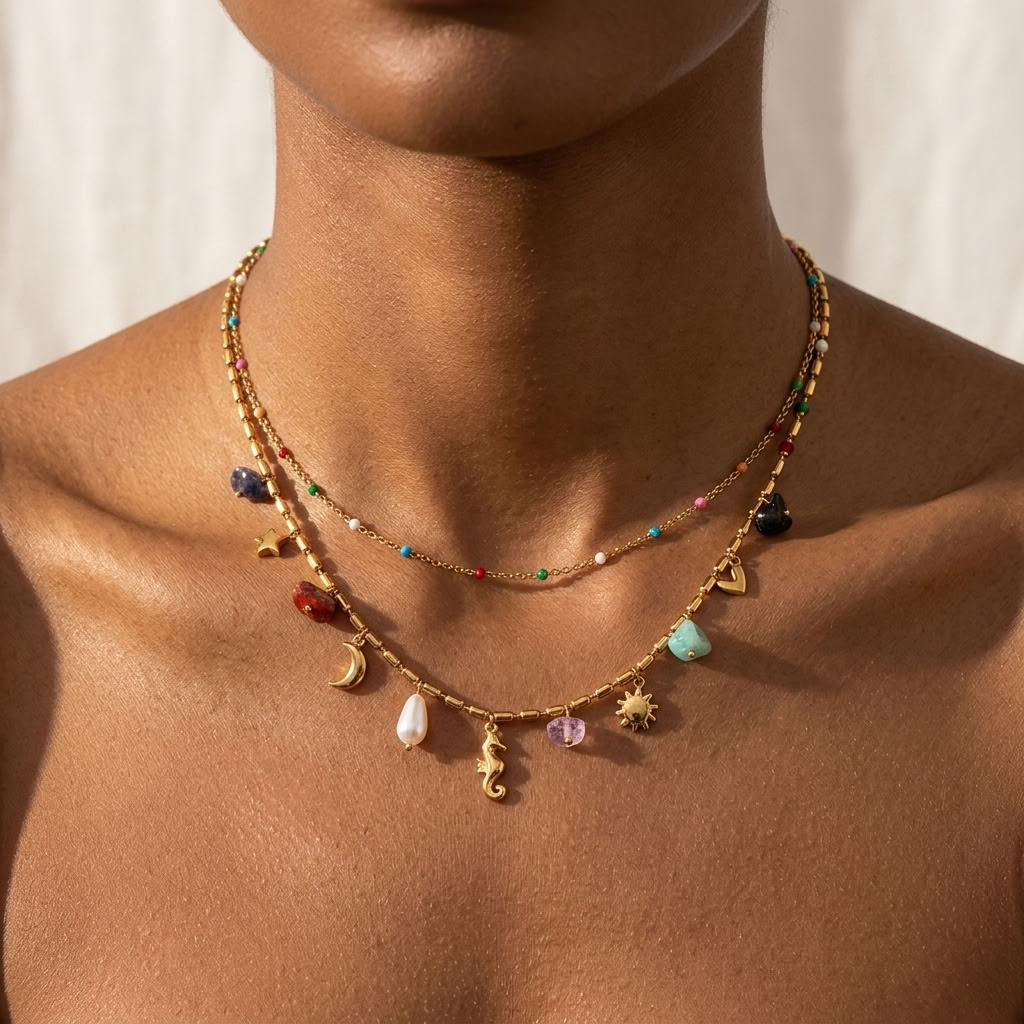 Woman wearing the Bohemia layered gold necklace hung with colorful stones, a pearl and a seahorse charm