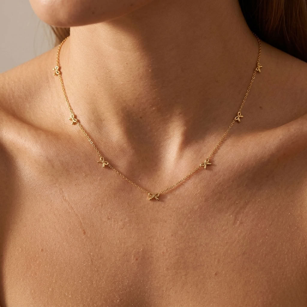 Woman wearing the Bianca multi-bow gold necklace, seven bows set into the chain around the neck