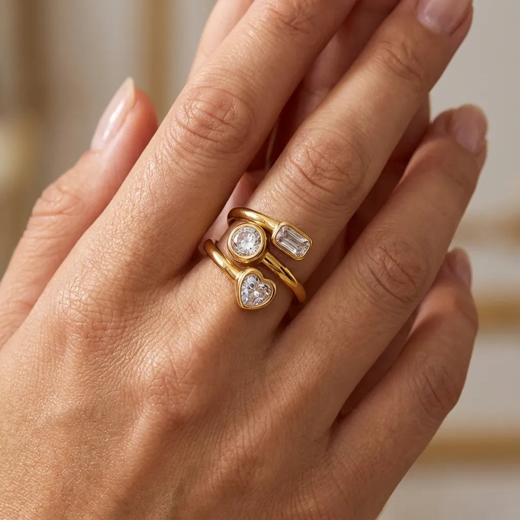 Woman wearing the Amelina gold wrap ring with heart, round and baguette crystals on her finger