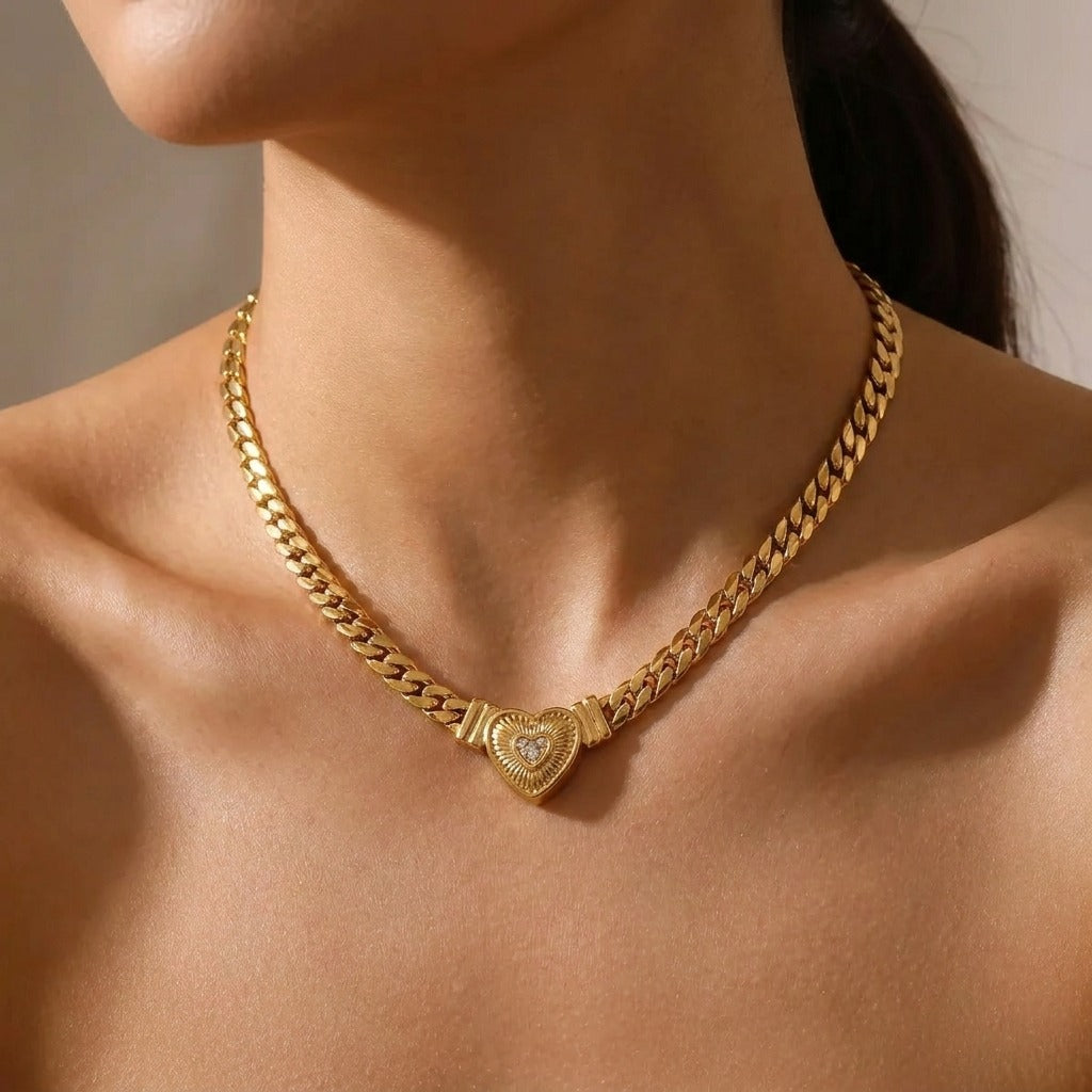 Woman wearing the Valentina heart necklace, a chunky gold curb chain with a ribbed heart at the front