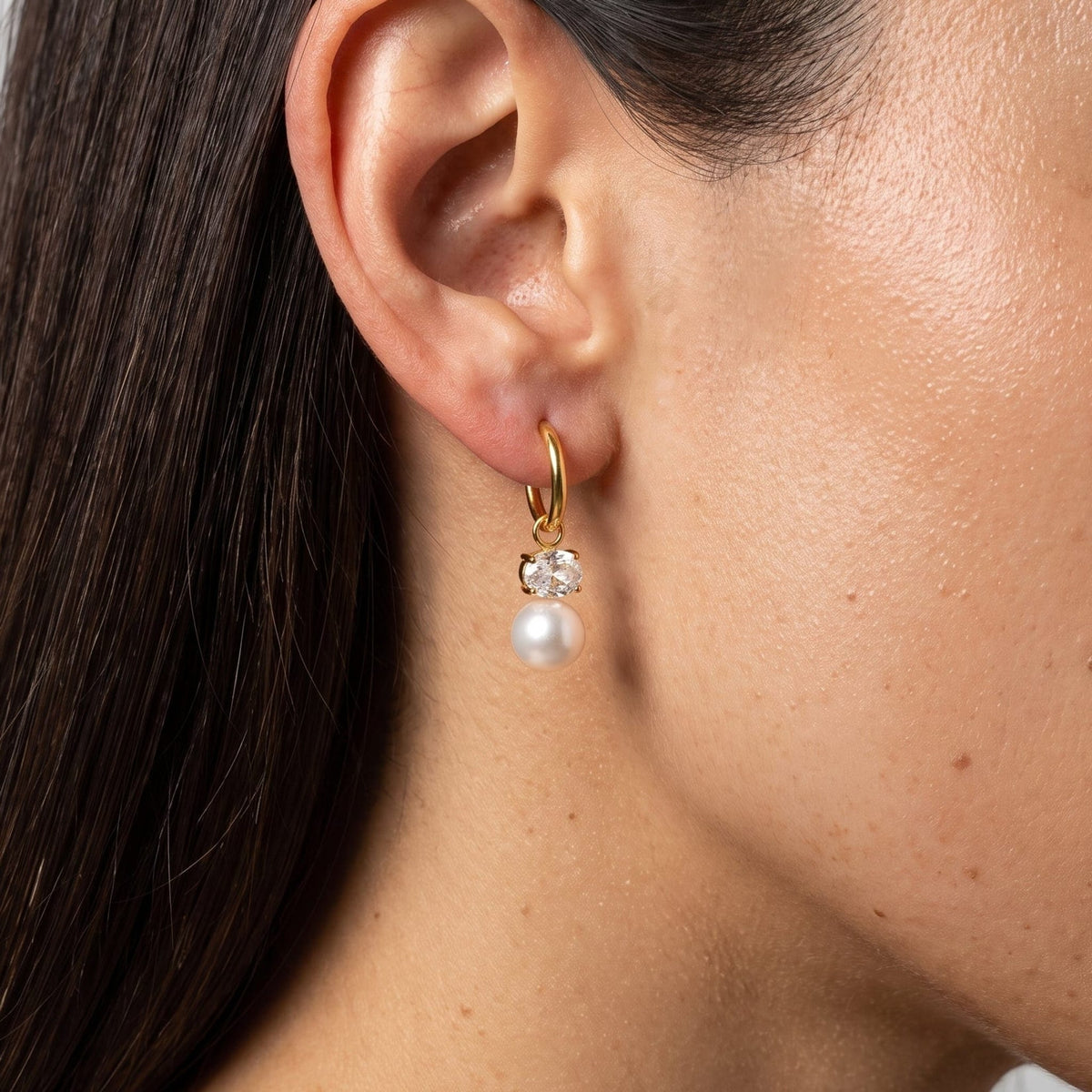 Woman wearing the Eléonore pearl drop gold earrings on the ear