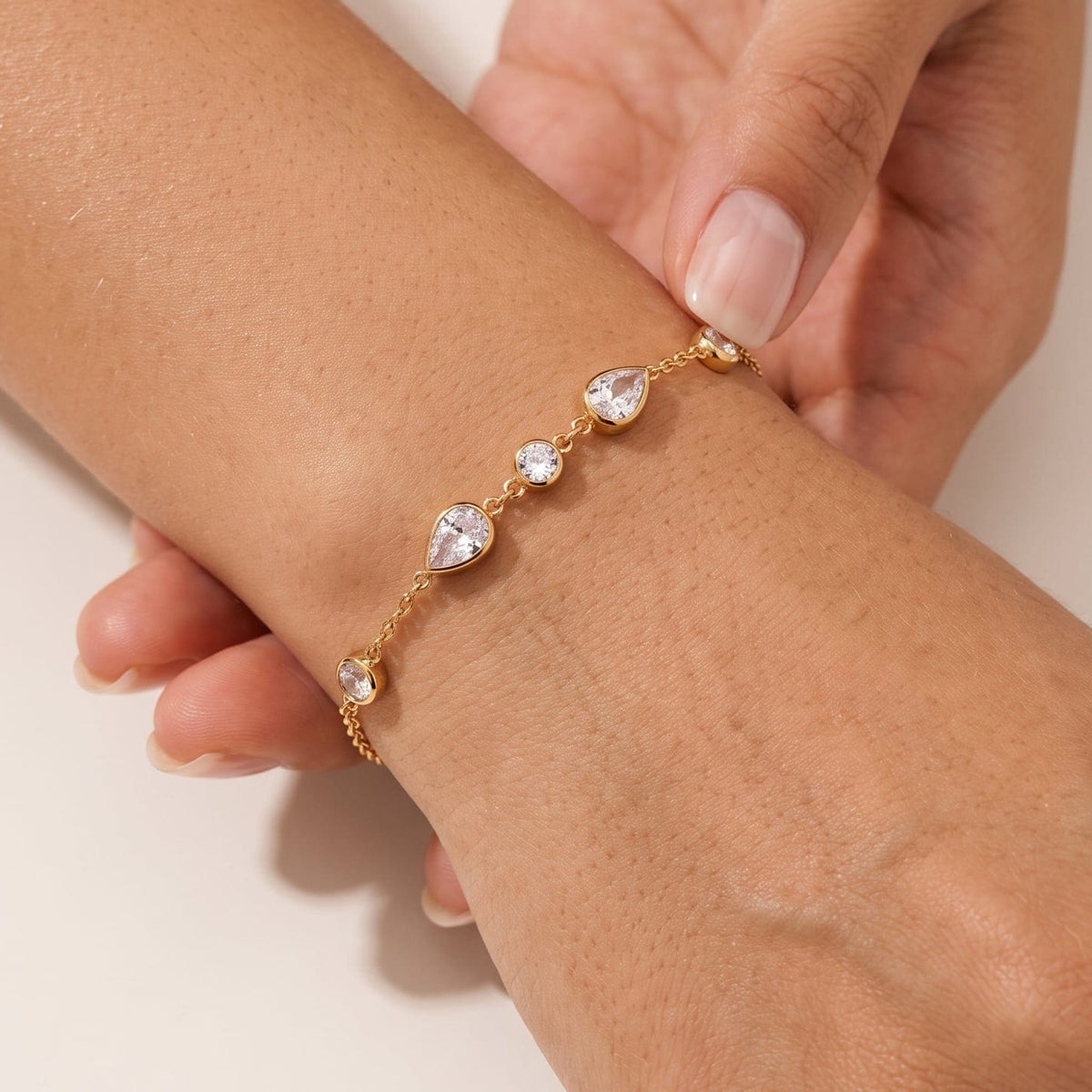 Woman wearing the Élise teardrop crystal gold bracelet on the wrist