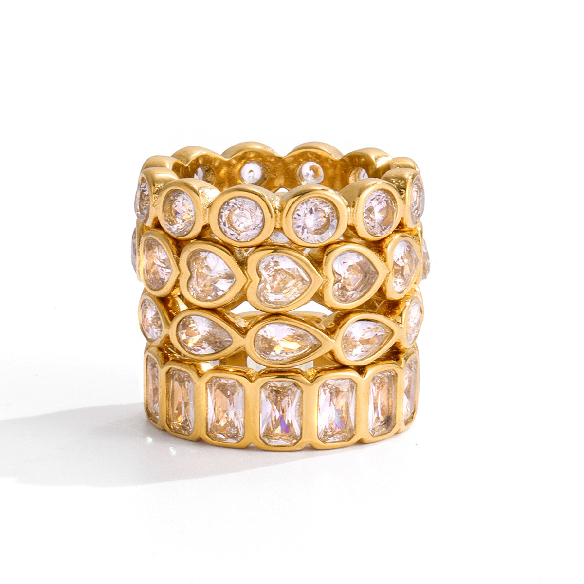 Stack of four clear crystal eternity gold rings, the pear band third from top