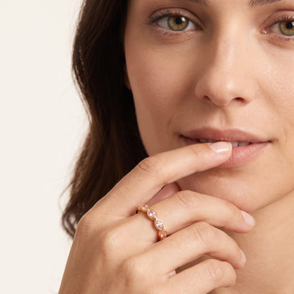 Woman wearing the lodie pink pear gold ring on the hand touching her lip