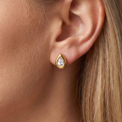 Woman wearing the Élodie teardrop bezel gold earrings on the ear