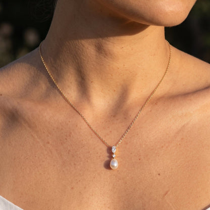Woman wearing the Emilia marquise pearl gold necklace at the collarbone
