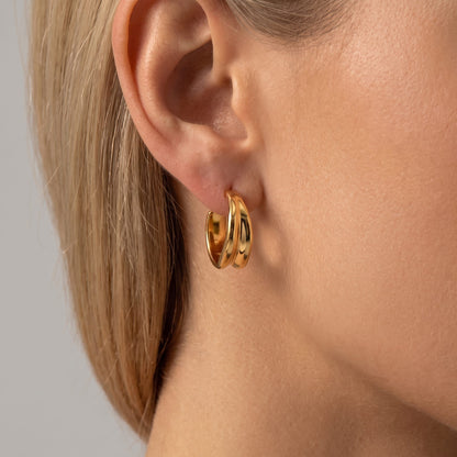 Woman wearing the Emily polished gold double-ridged hoop earring