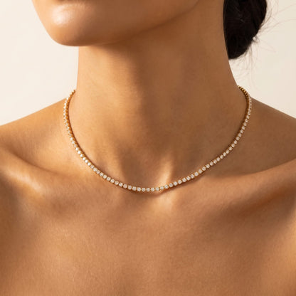 Close-up of a woman wearing the Emma tennis chain gold necklace at the base of her neck