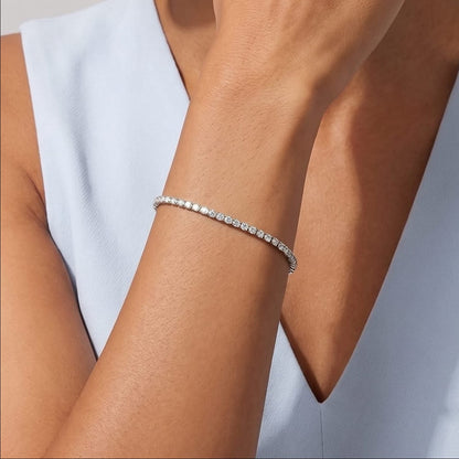Wider view of a woman wearing the Emma tennis chain silver bracelet on the wrist