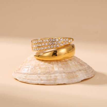 Evelyne pavé wrap gold ring on a seashell against a neutral background