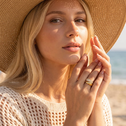 Woman wearing the Evelyne pavé wrap gold ring on the hand wearing a straw hat