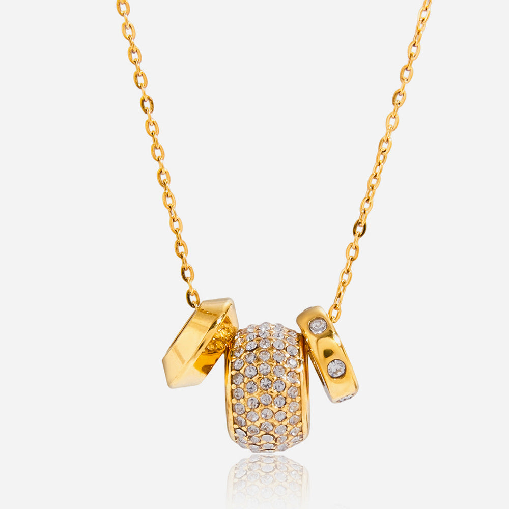 Fiona pavé rondelle gold necklace on white: a crystal barrel bead between two gold rondelle charms