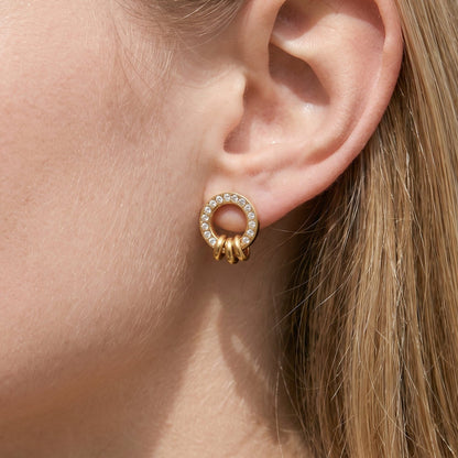 Woman wearing the Gabrielle triple ring gold earrings on the ear