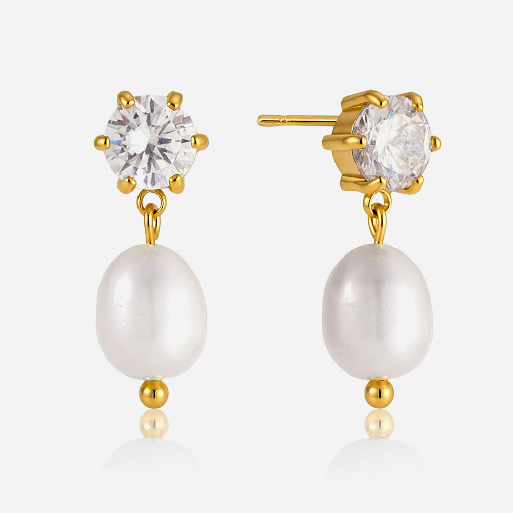 Close view of the Ginevra pearl drops hanging from claw-set crystal studs on pale gray