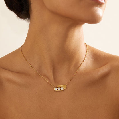 Wider view of a woman wearing the Ginevra triple heart gold necklace at the collarbone