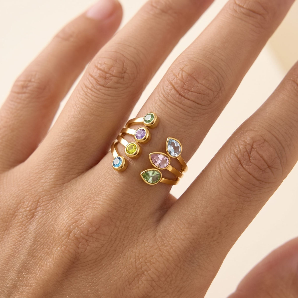 Close-up of the Giulia pastel crystal gold ring worn on a ring finger