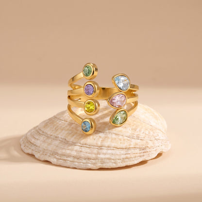 The Giulia pastel crystal gold ring resting on a seashell