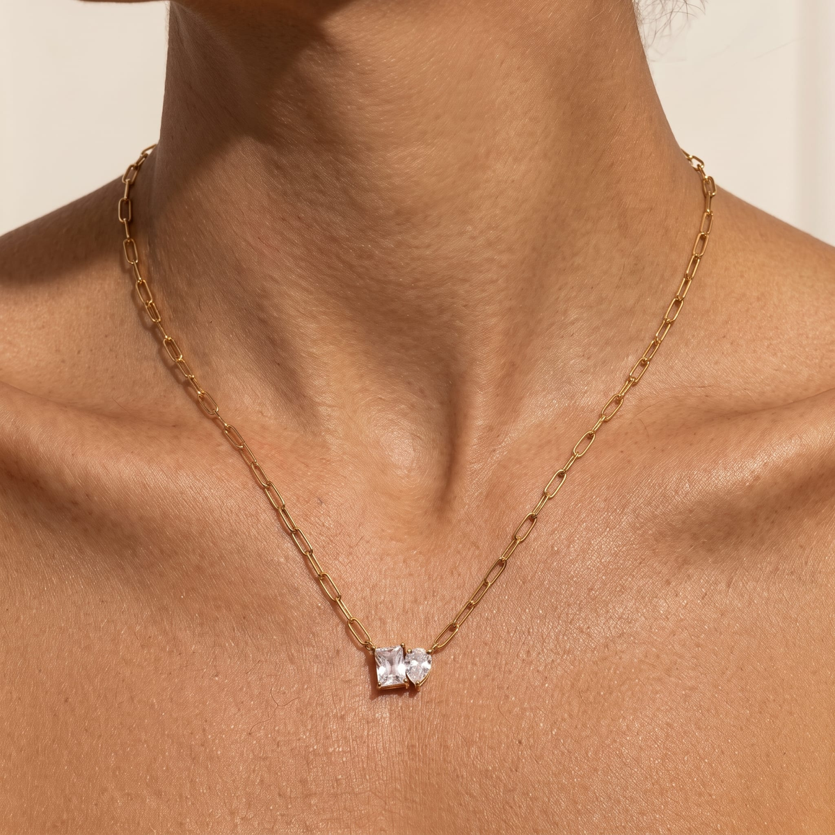 Woman wearing the Giulia twin crystal gold necklace at the collarbone, featuring two clear crystals