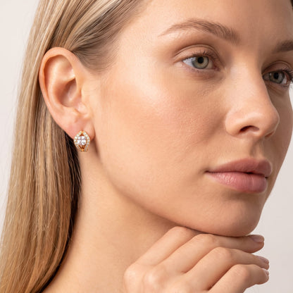 Woman wearing the Ilaria cushion halo gold earrings on the ear with hand under her chin