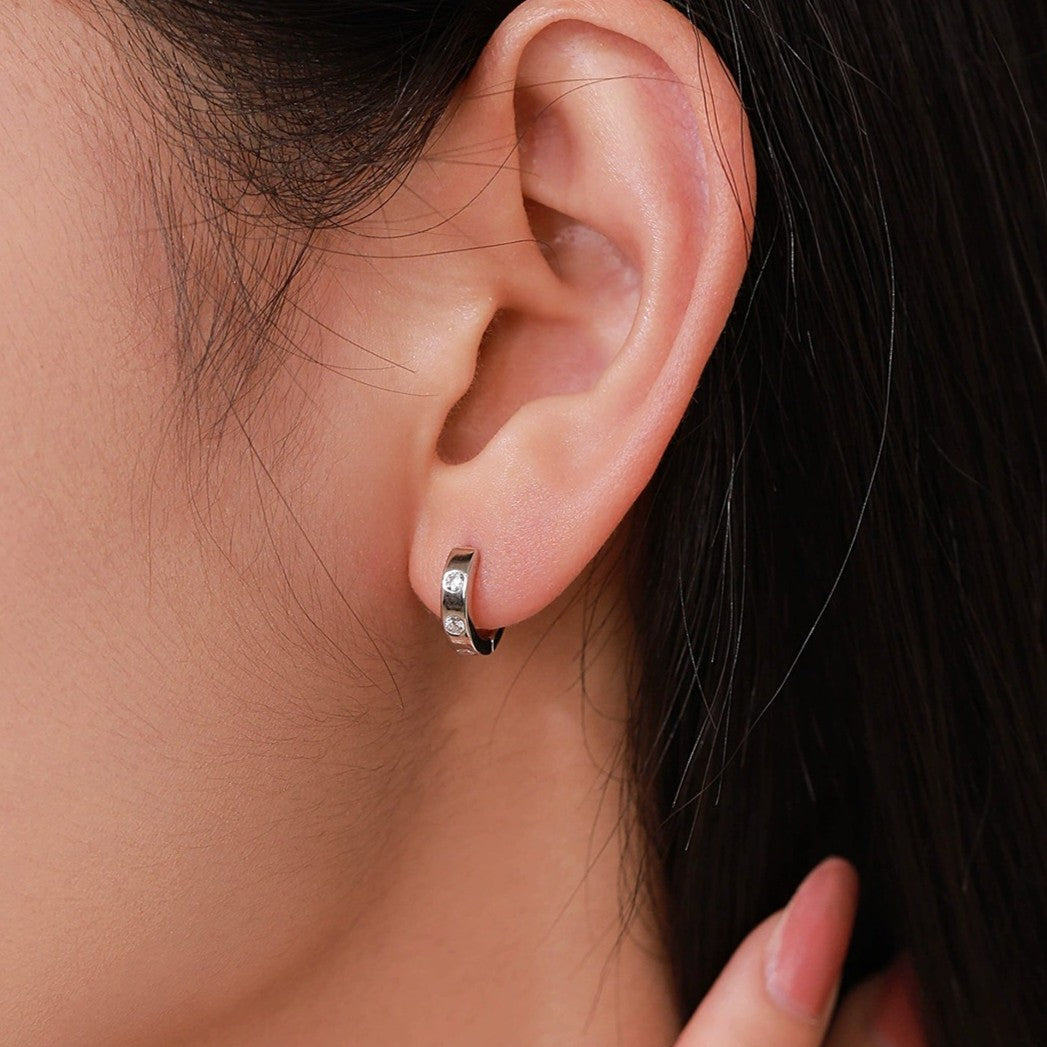 Woman wearing a Lilou minimalist silver huggie set with small crystals on the ear lobe