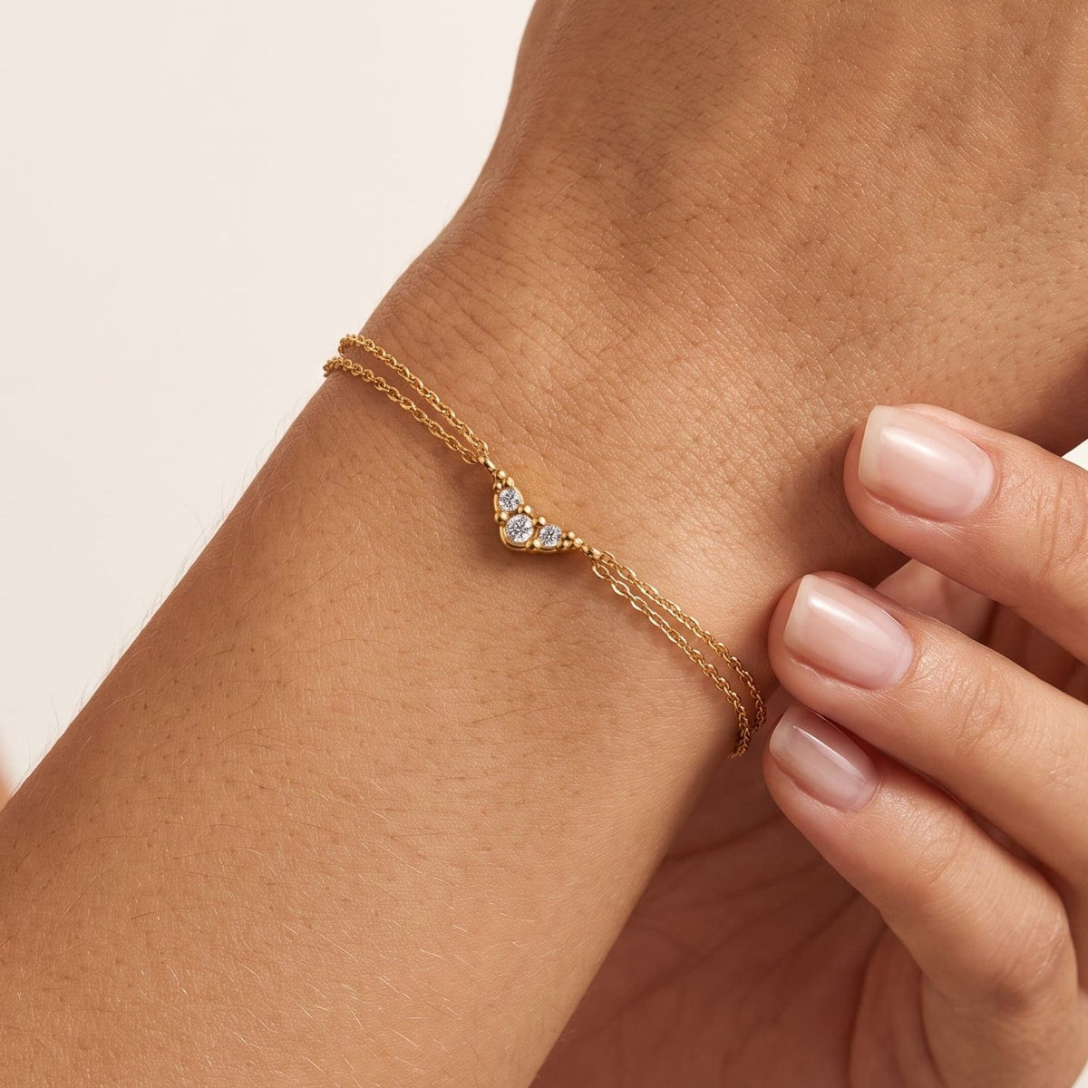 Woman wearing the Inès crystal chevron gold bracelet on the wrist