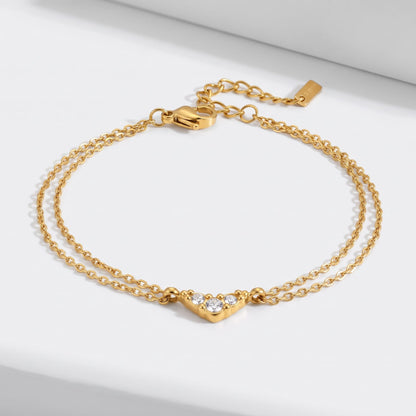 Inès crystal chevron gold bracelet on a white surface with the double chain spread out