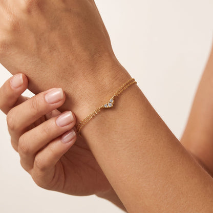 Wider view of a woman wearing the Inès crystal chevron gold bracelet on the wrist