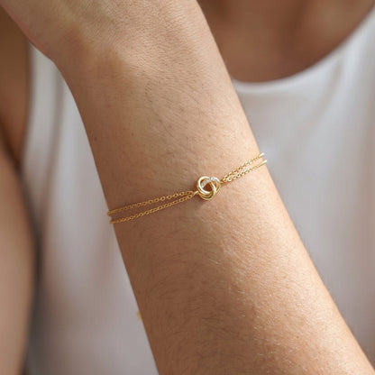 Woman wearing the Juliette love knot gold bracelet on the wrist