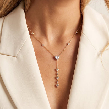 Woman wearing the Justine heart cascade gold necklace at the collarbone