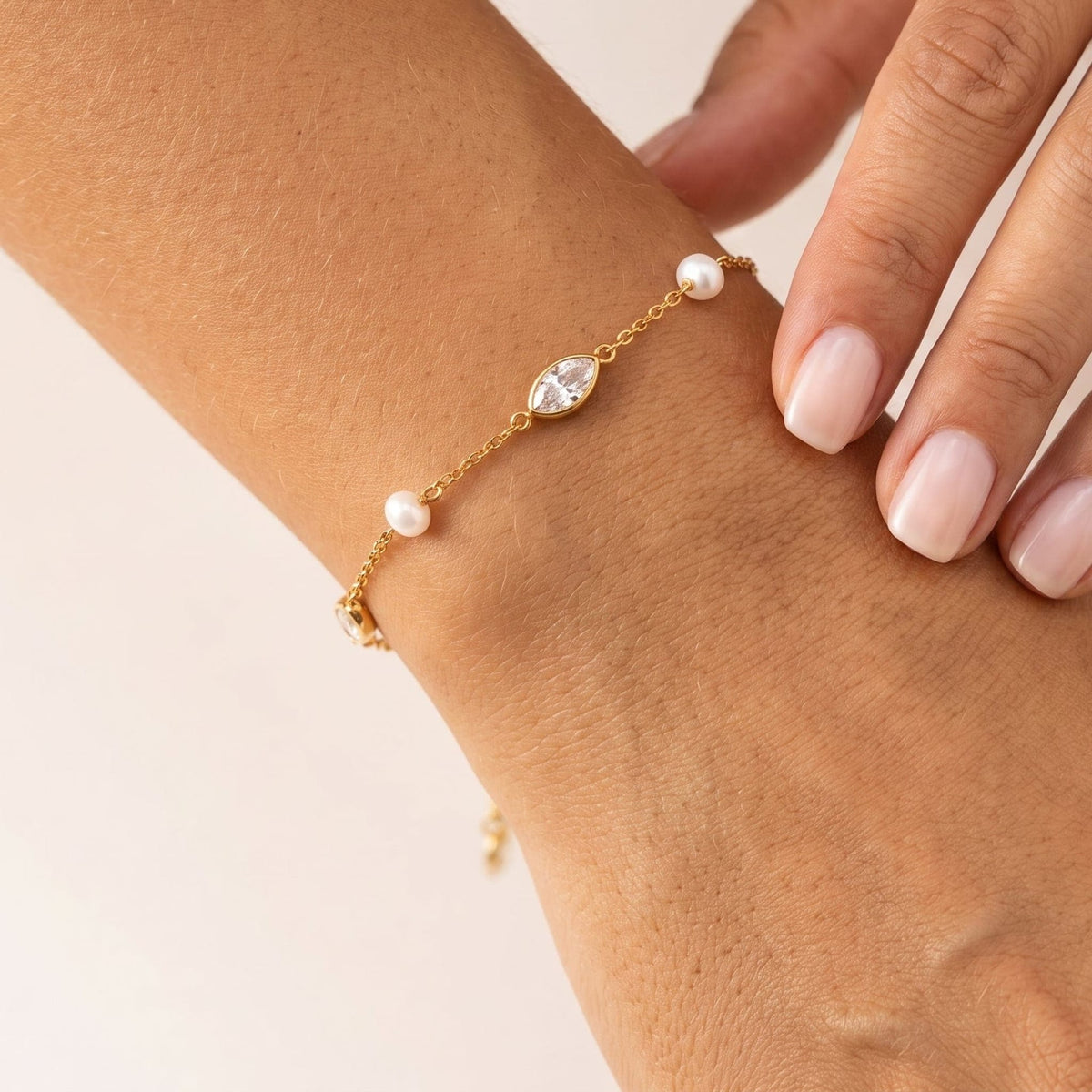 Woman wearing the Liana marquise pearl gold bracelet on the wrist