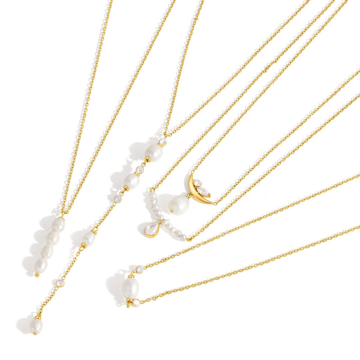 Lisette pearl bar with a teardrop crystal among gold pearl necklaces on a white background