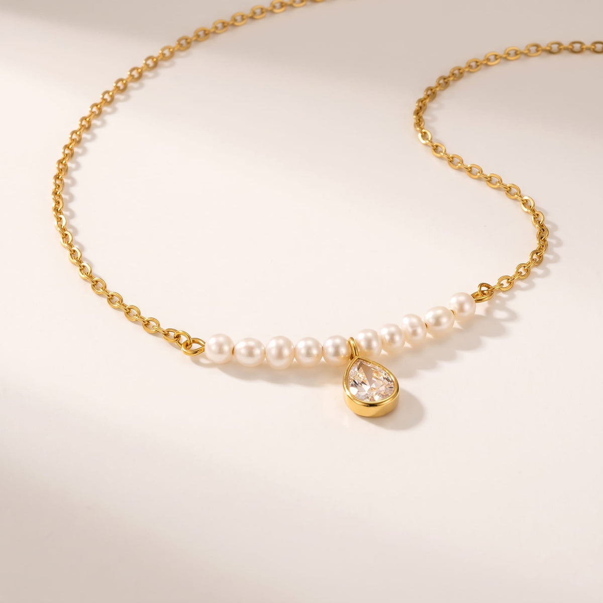 Lisette pearl bar gold necklace on a smooth white surface under soft lighting
