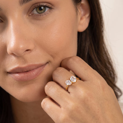Woman wearing the Manon pear duo gold ring on the hand resting near her cheek