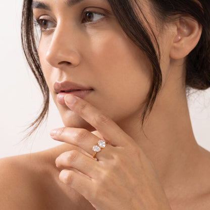 Woman wearing the Manon pear duo gold ring on the hand touching her lower lip