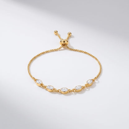 Marisa oval crystal gold bracelet on a white surface with five bezel set stones