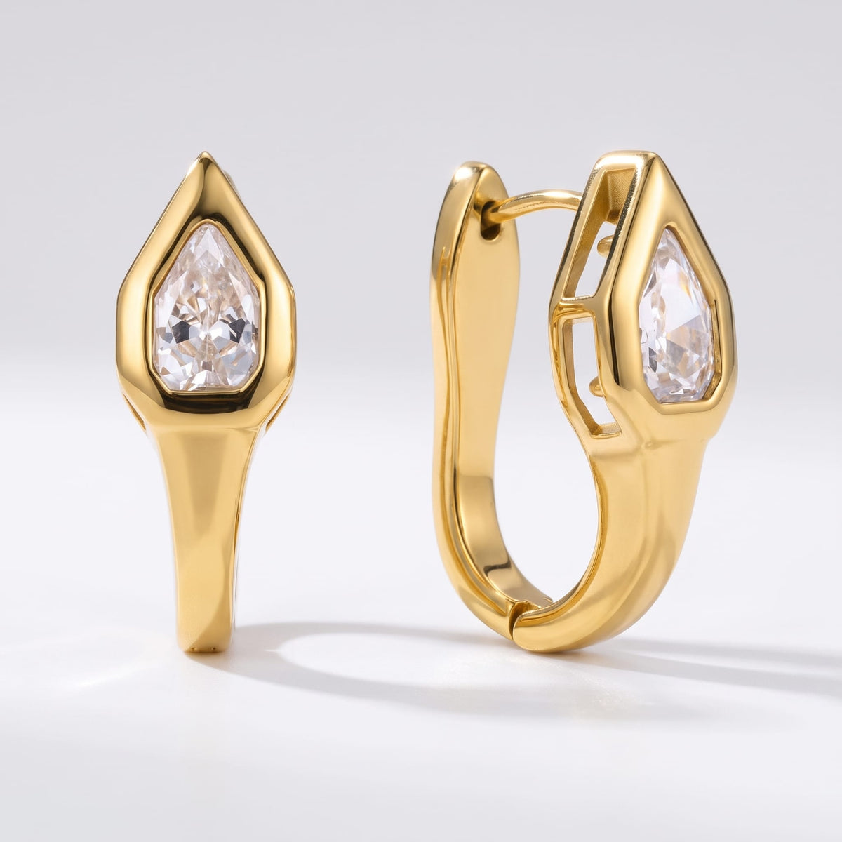 Mireille pear bezel gold earrings on a plain white surface displaying front and side views