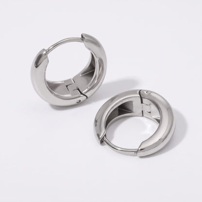 Nina dome huggie silver earrings on a plain white surface