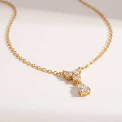 Noémie crystal teardrop gold necklace on a white surface with soft light and delicate shadows