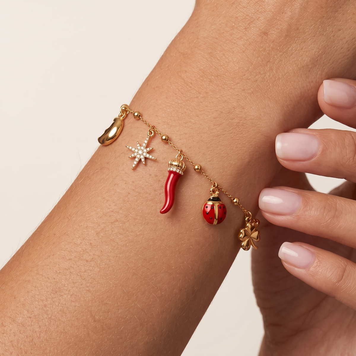 Woman wearing the lucky charms gold bracelet on the wrist, with a ladybug charm