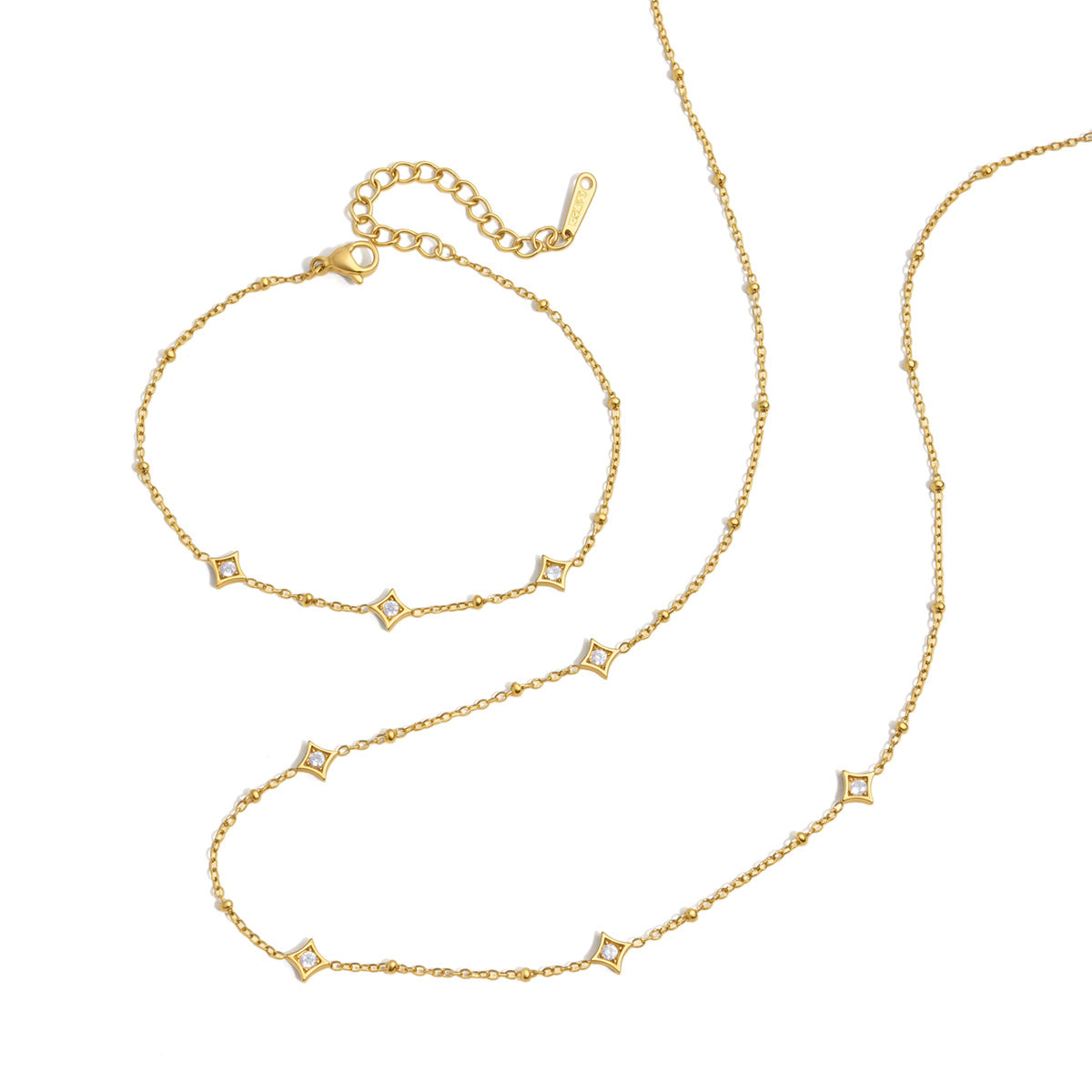Océane star station bracelet with its extender chain, laid above the matching necklace on white