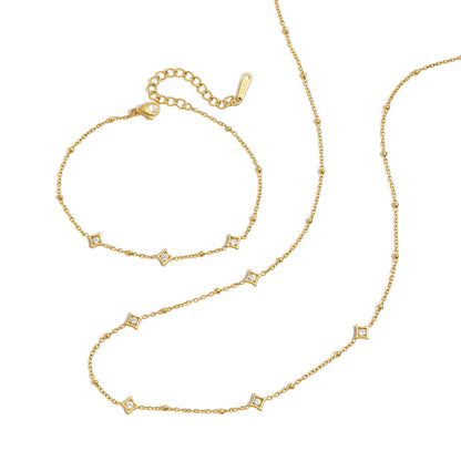 Océane star station bracelet with its extender chain, laid above the matching necklace on white